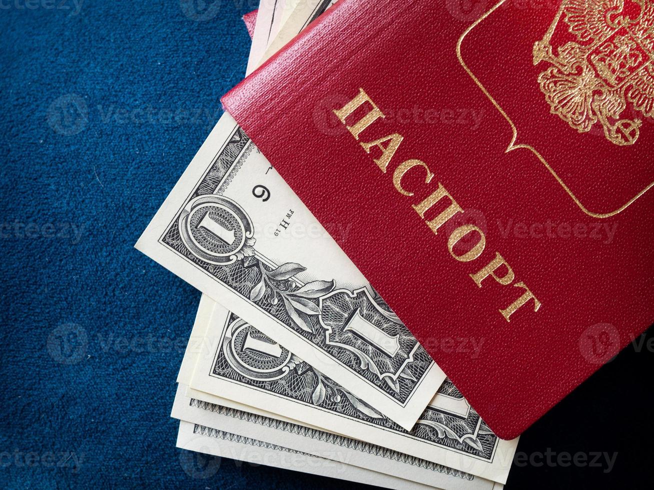 un passeport étranger et des dollars sur fond bleu. photo