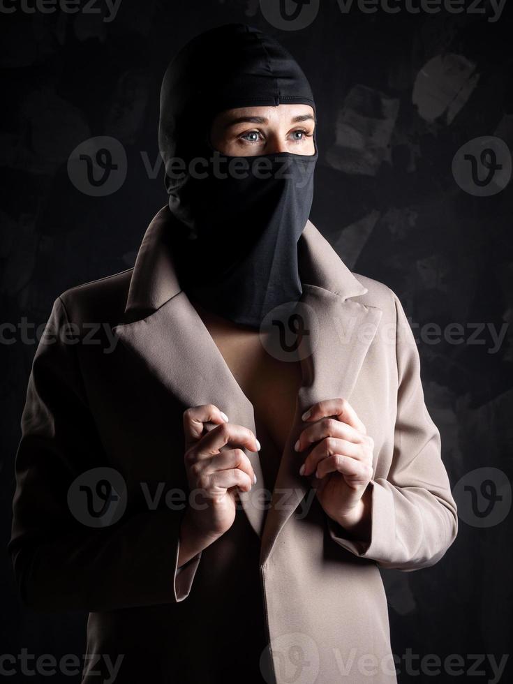 portrait d'une jeune fille dans une cagoule noire et un manteau beige. photo