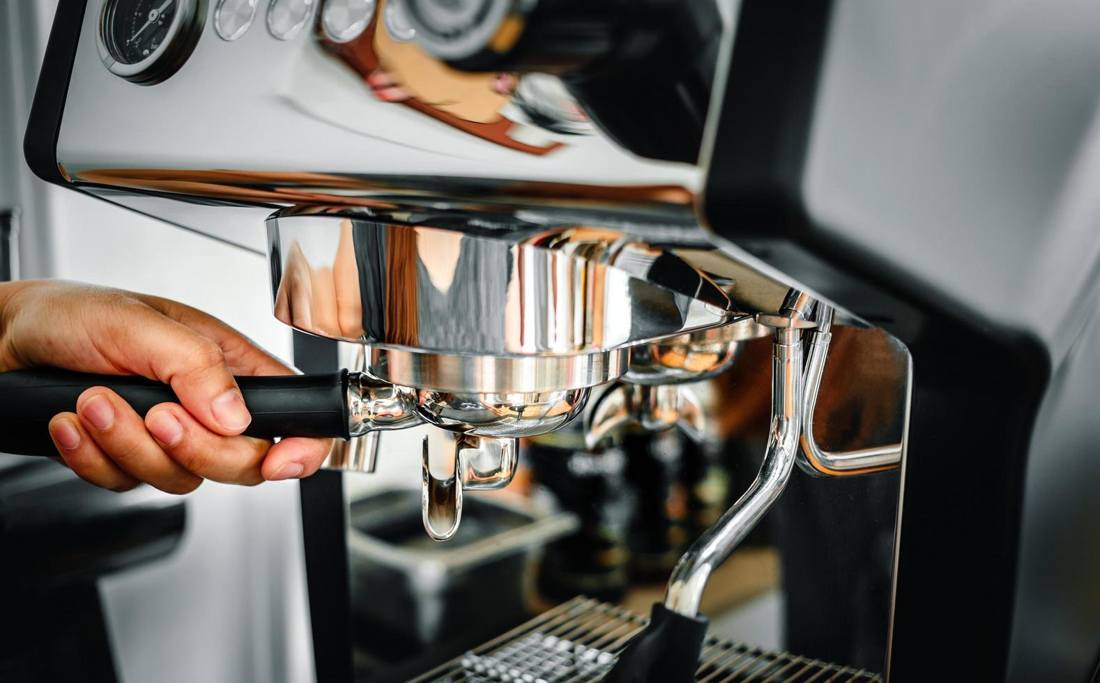 gros plan d'un barista à la main faisant du café frais processus de préparation d'une tablette de café avant de l'installer dans la machine à café photo