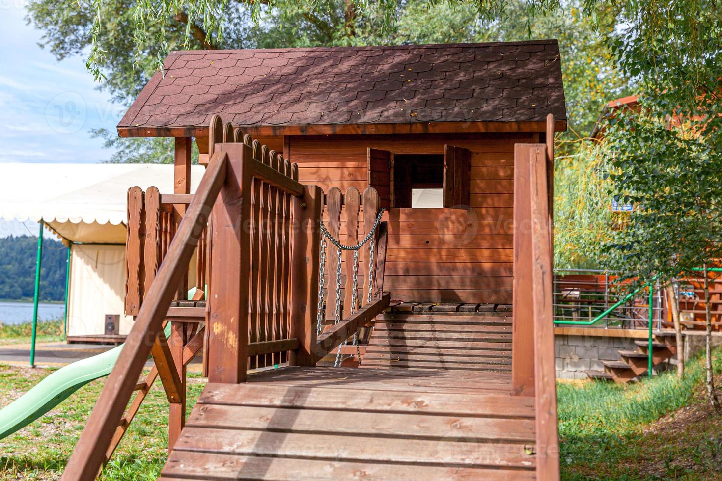 aire de jeux pour enfants en bois moderne vide située sur une cour verte dans un parc public en été. terrain de jouets amusant pour les enfants. activités d'exercice urbain pour enfant à l'extérieur. concept d'enfance de quartier. photo