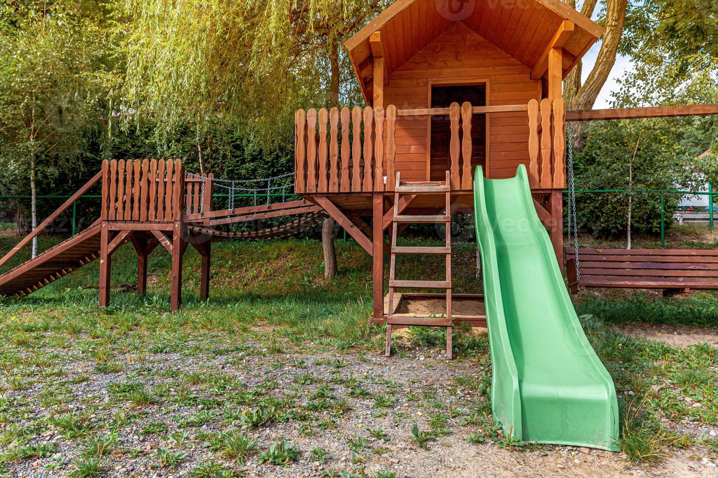 aire de jeux pour enfants en bois moderne vide située sur une cour verte dans un parc public en été. terrain de jouets amusant pour les enfants. activités d'exercice urbain pour enfant à l'extérieur. concept d'enfance de quartier. photo