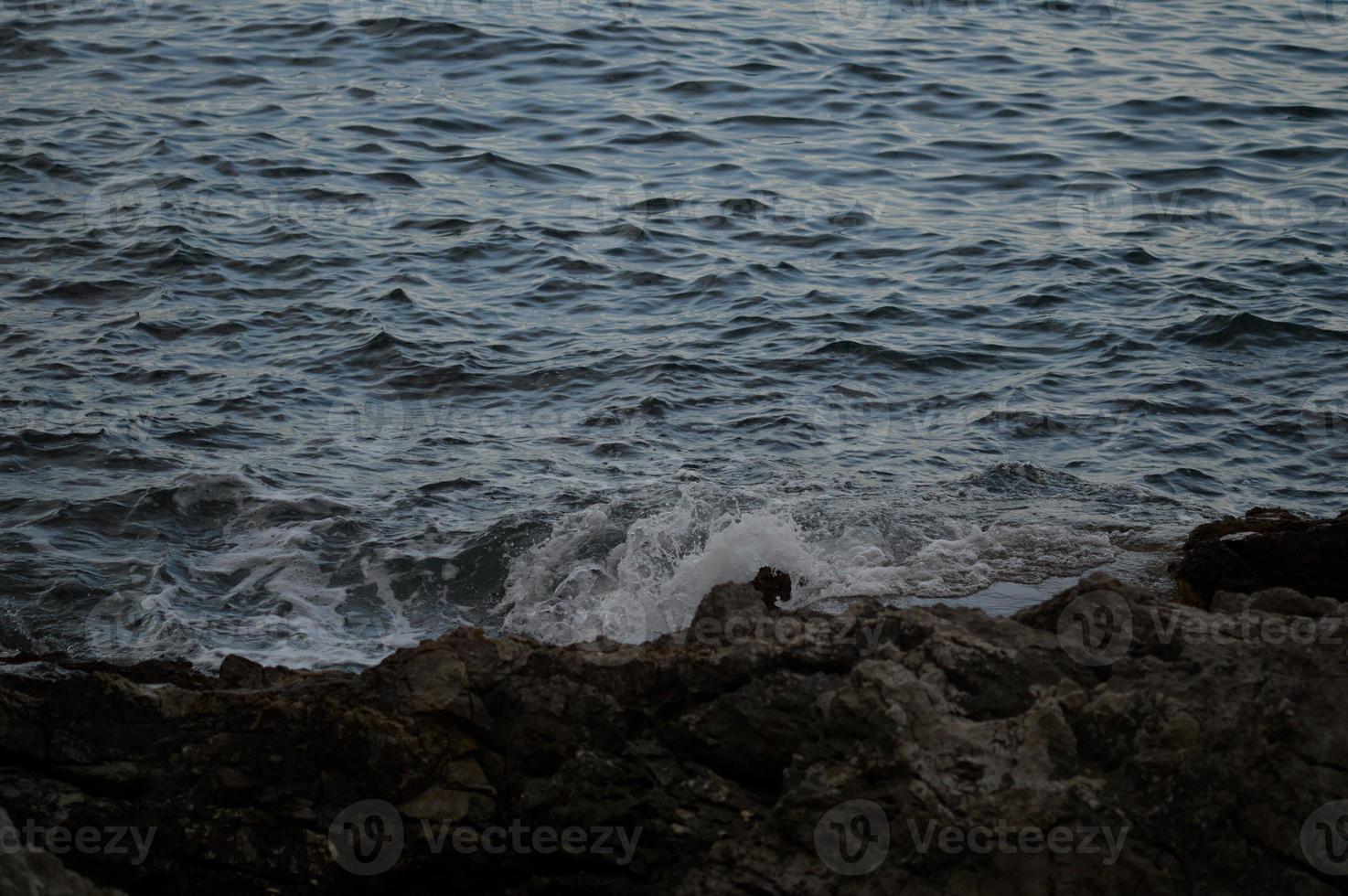 vagues de la mer se brisant sur les rochers. photo