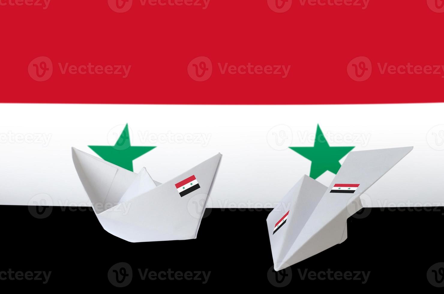drapeau de la syrie représenté sur un avion et un bateau en papier origami. concept d'art fait à la main photo