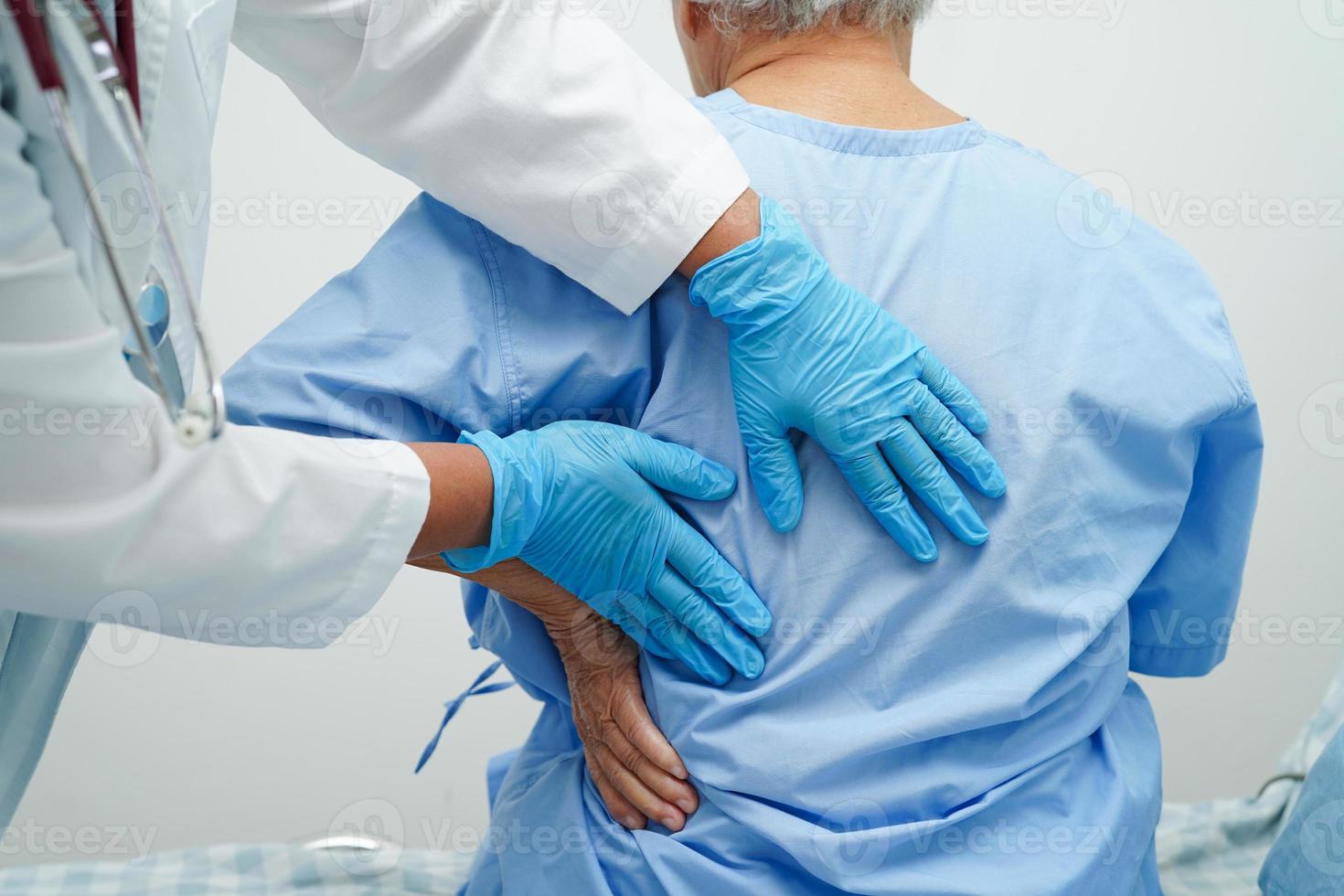 le médecin examine et traite le problème de douleur musculaire du dos des patients âgés asiatiques et la thérapie physique à l'hôpital. photo