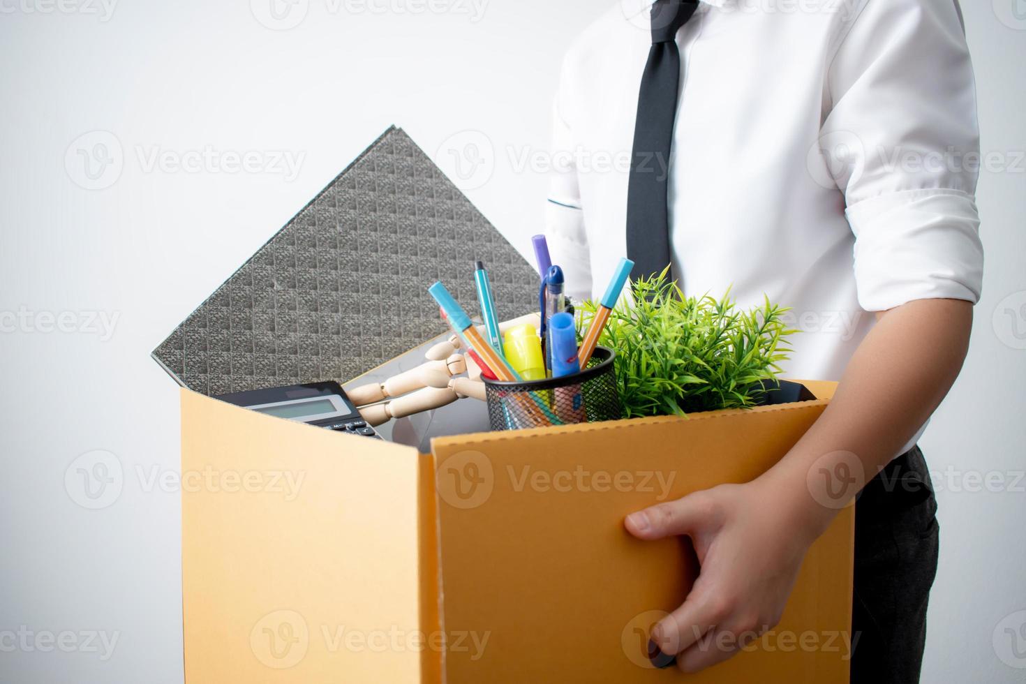 l'employé a été licencié pour avoir transporté une boîte en carton marron avec son équipement. concept de chômeurs et de l'économie photo