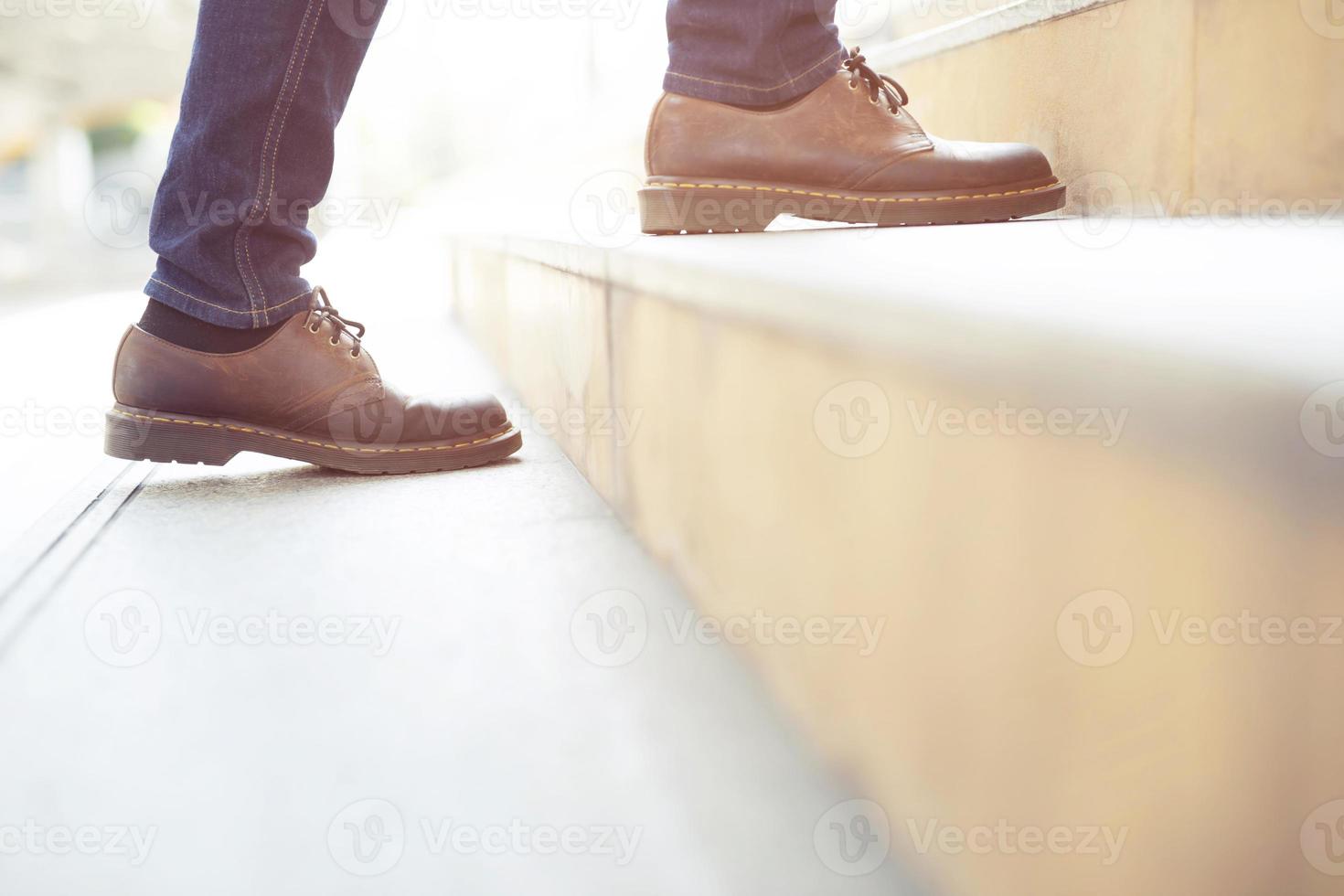 homme d'affaires moderne travaillant les jambes en gros plan en montant les escaliers dans la ville moderne. à l'heure de pointe pour travailler au bureau à la hâte. lors de la première matinée de travail. escalier photo