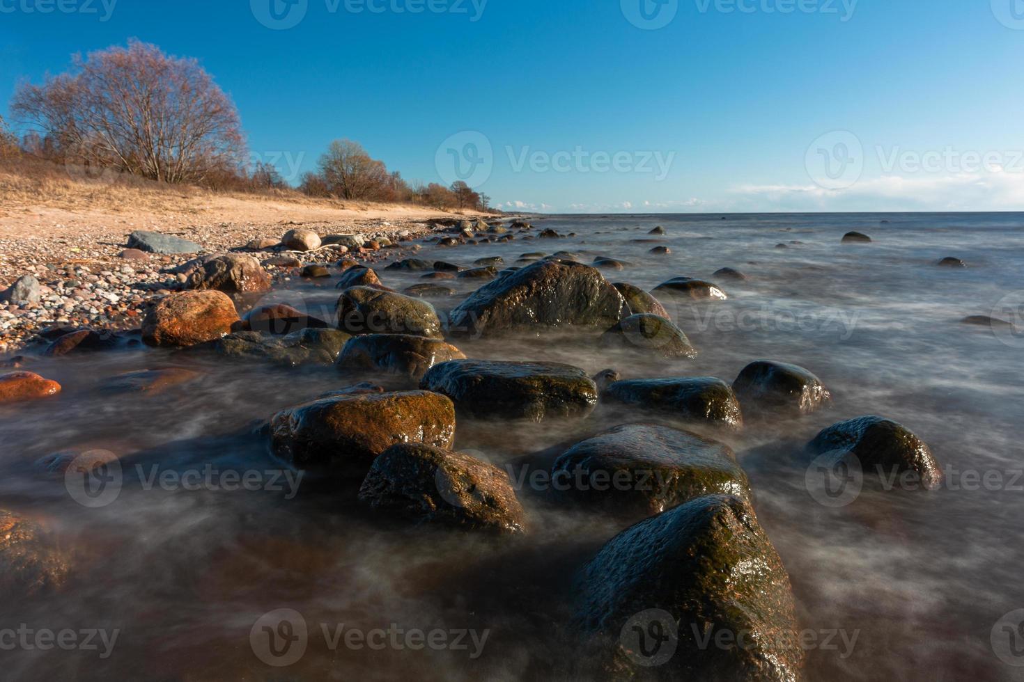 pierres sur la côte de la mer baltique au coucher du soleil photo