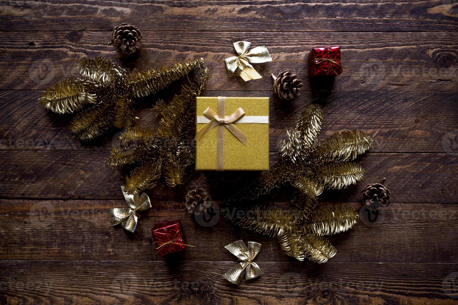 mise à plat de noël vintage dans des couleurs dorées et rouges.boîte cadeau brillante entourée d'un élément de décoration et de branches de sapin peintes en or photo