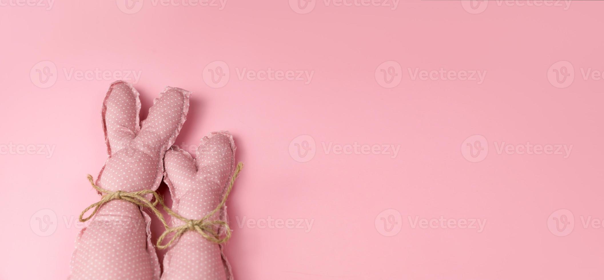 bannière de pâques rose monochrome avec des lapins jouets. place pour le texte photo
