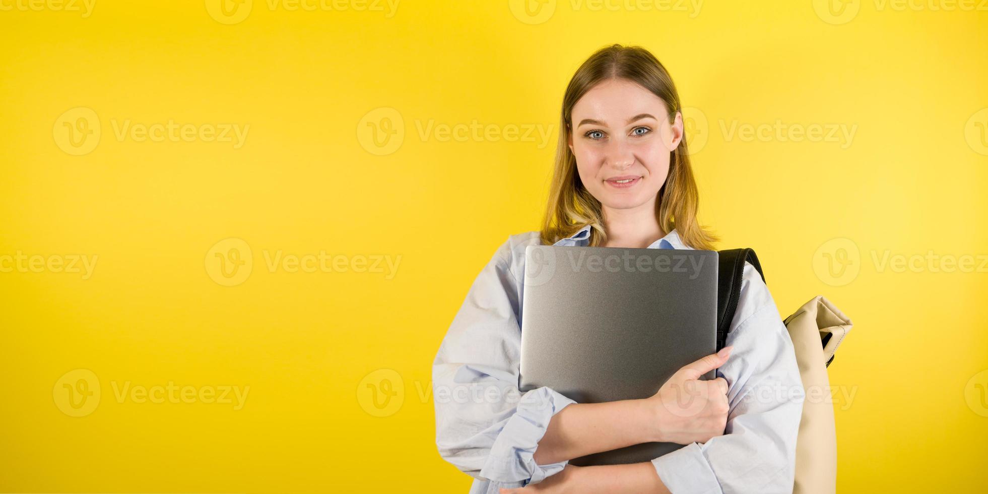Happy smiling female student studio portrait sur fond jaune.copyspace banner photo
