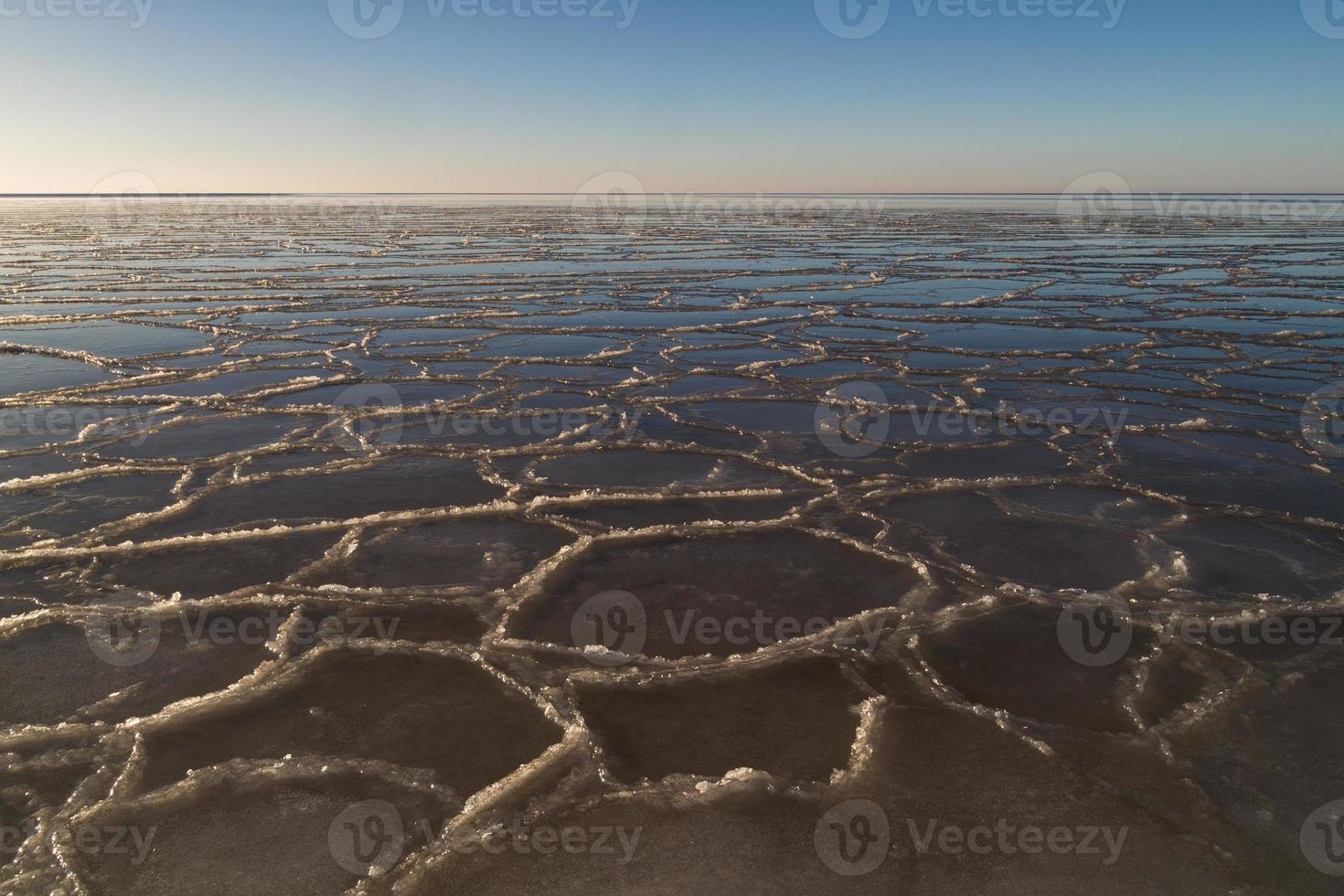 côte de la mer baltique avec galets et glace au coucher du soleil photo