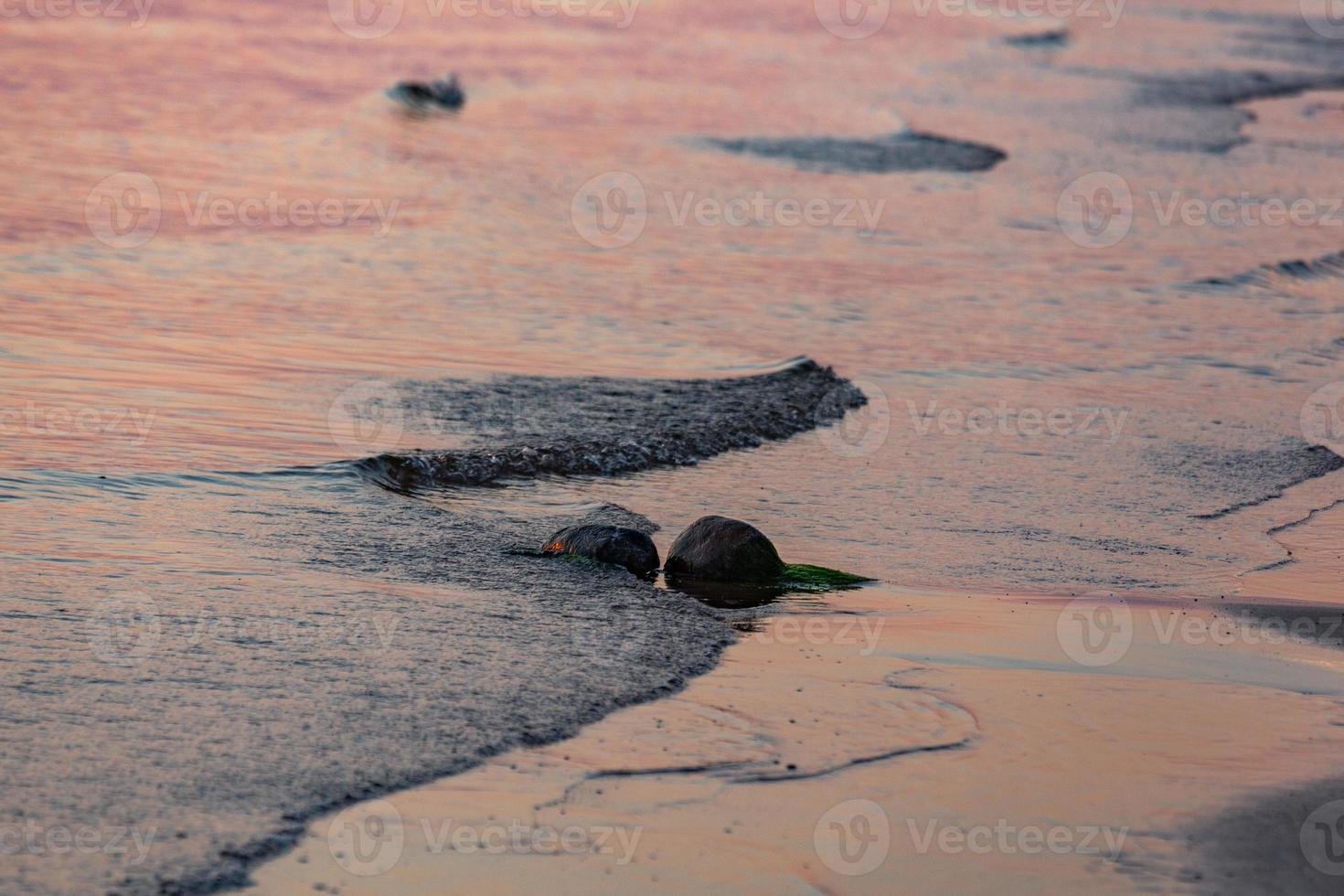 couleurs du coucher du soleil dans l'eau de mer photo