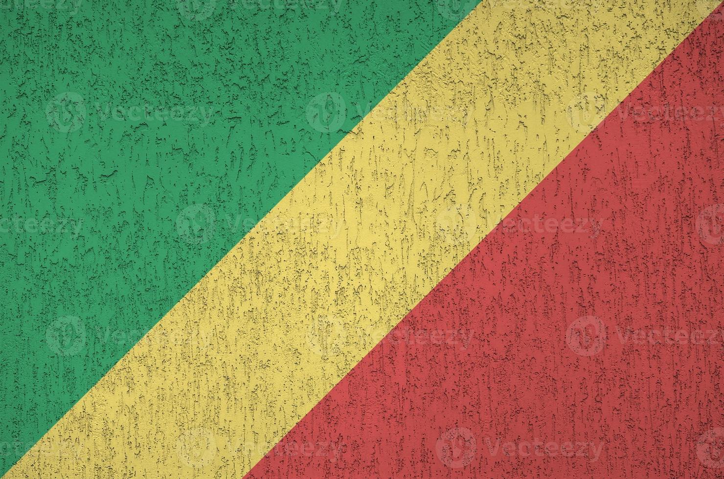 drapeau du congo représenté dans des couleurs de peinture vives sur un vieux mur de plâtrage en relief. bannière texturée sur fond rugueux photo