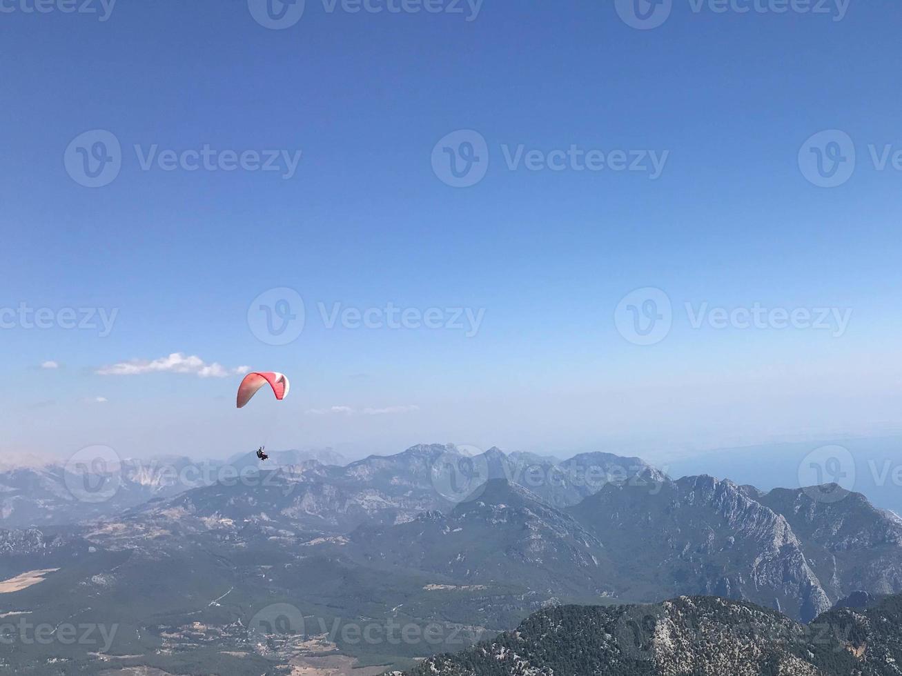 parachutiste avec un auvent bleu foncé sur le fond un ciel bleu au-dessus des nuages photo