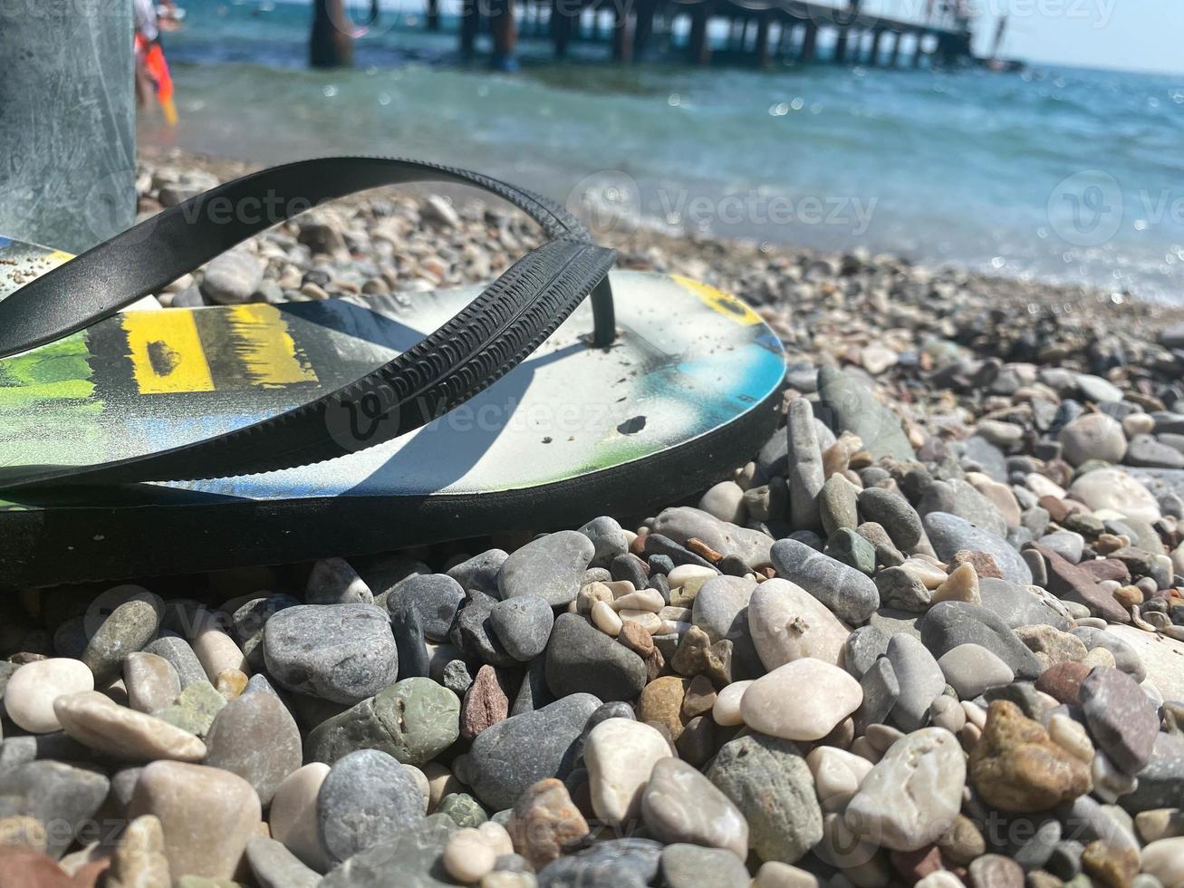 tongs vertes sur la plage de galets photo