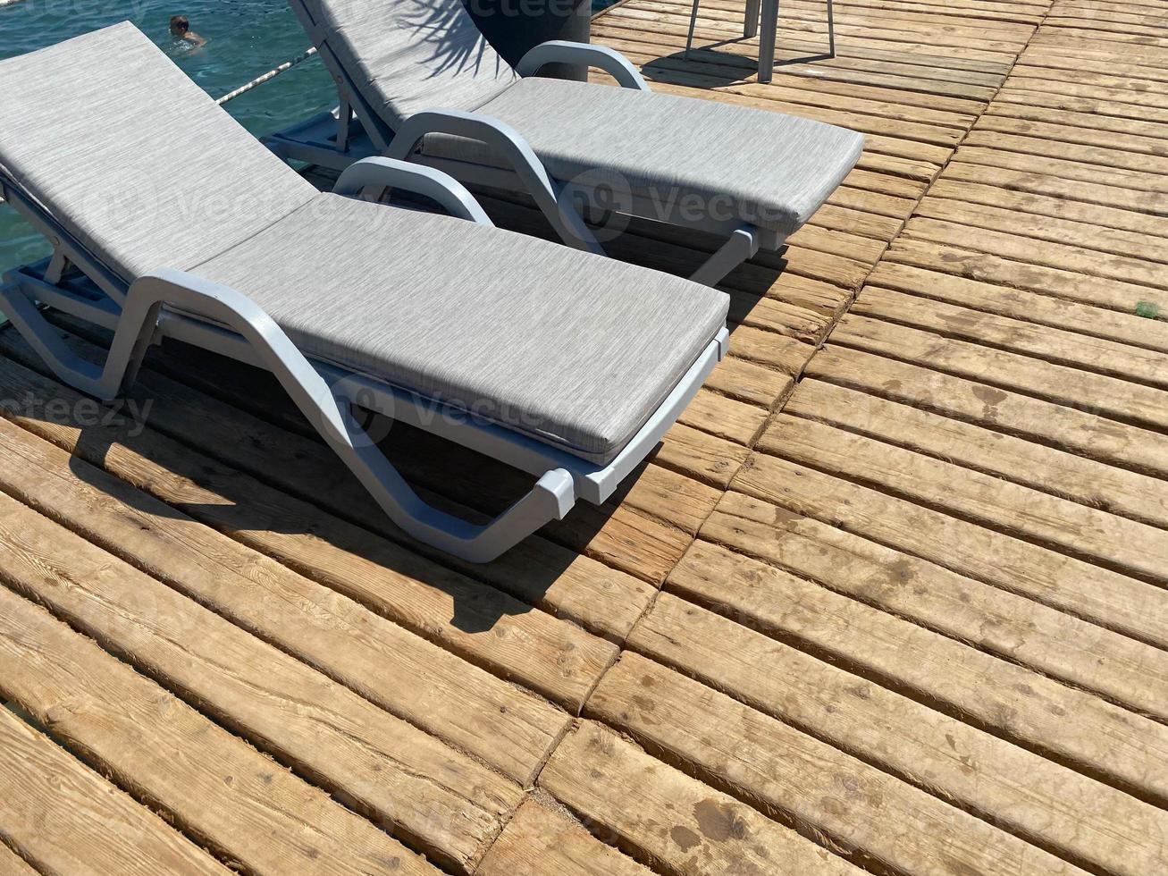 chaises longues vides sur la plage de sable dans le contexte de la jetée, soirée, mer calme, déserte, humeur photo