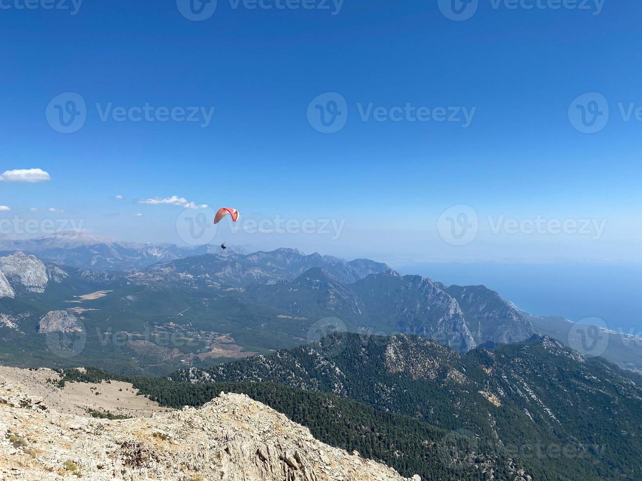 un parachute coloré avec parachutiste sur fond de ciel bleu ensoleillé. mode de vie actif. sport extrême. concept de vacances, vacances, tourisme. horizontal. vue aérienne de rio de janeiro avec de l'eau turquoise photo