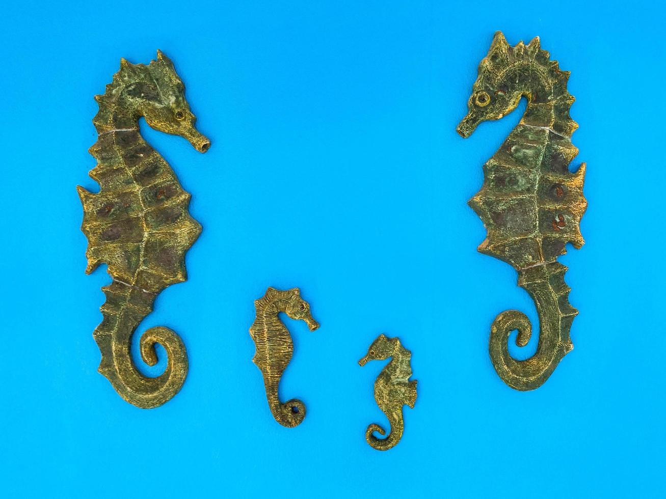 hippocampe en bois. figurine en forme de poisson en matériaux naturels. appât pour la pêche, poisson sur fond bleu mat photo