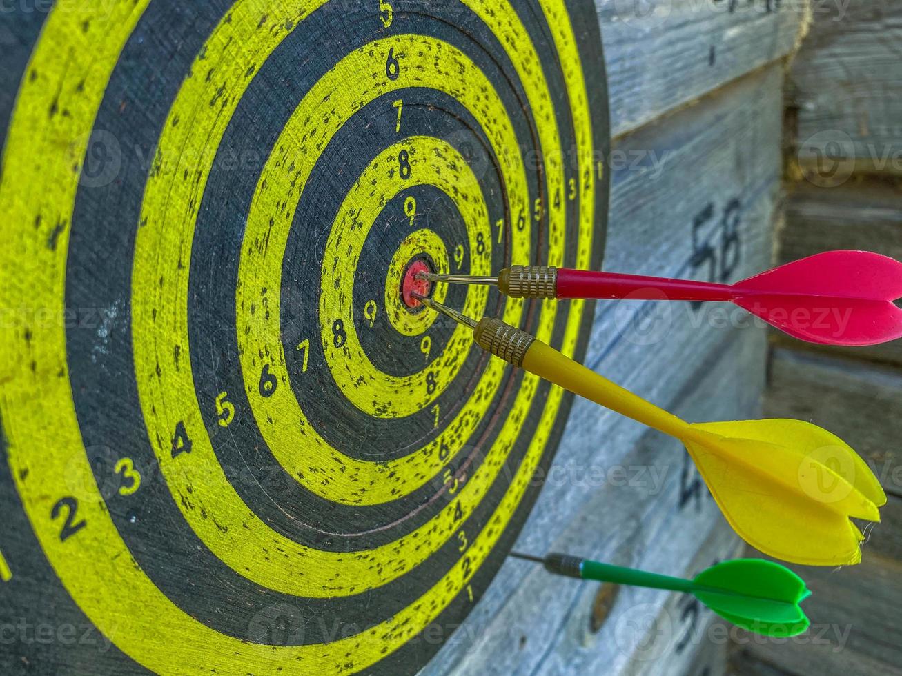 jeux de plein air actifs. fléchettes avec des fléchettes. tirer une fléchette avec une plume directement sur la cible. champ jaune avec des points de marques. jeu de précision photo