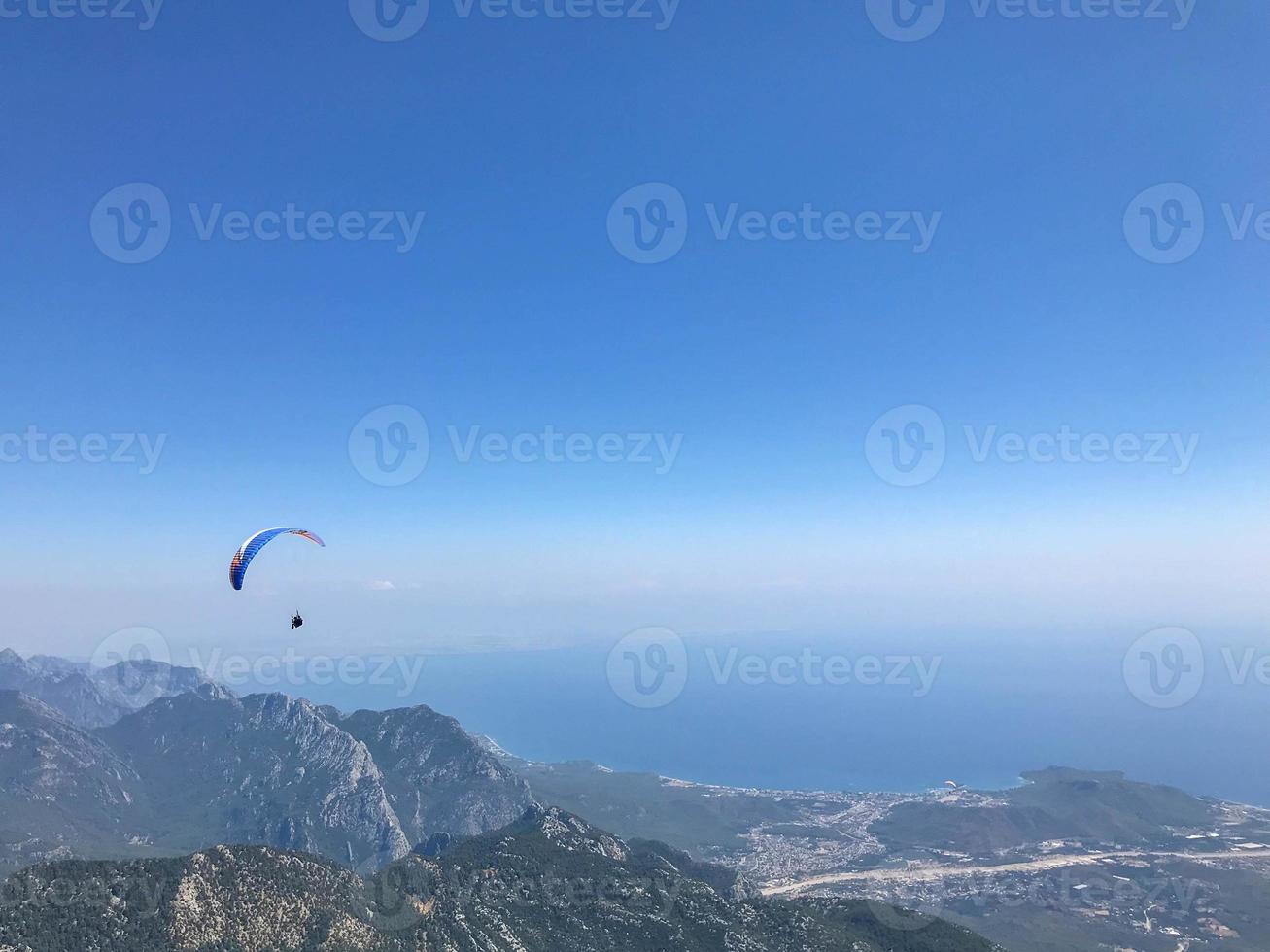 parapentes volant depuis le sommet de la montagne tahtali près de kemer, province d'antalya en turquie. concept de mode de vie actif et d'aventure sportive extrême photo