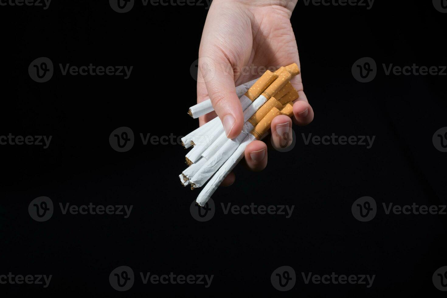 la main donne un paquet de cigarettes sur le noir photo