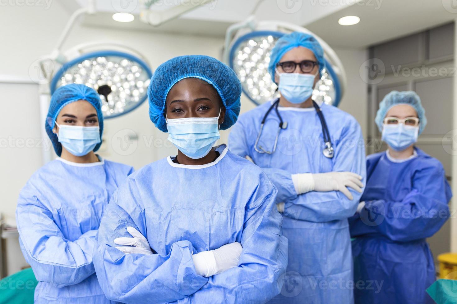 portrait d'une équipe médicale multiculturelle debout dans une salle d'opération. portrait de travailleurs médicaux en uniforme chirurgical en salle d'opération, prêts pour la prochaine opération. photo