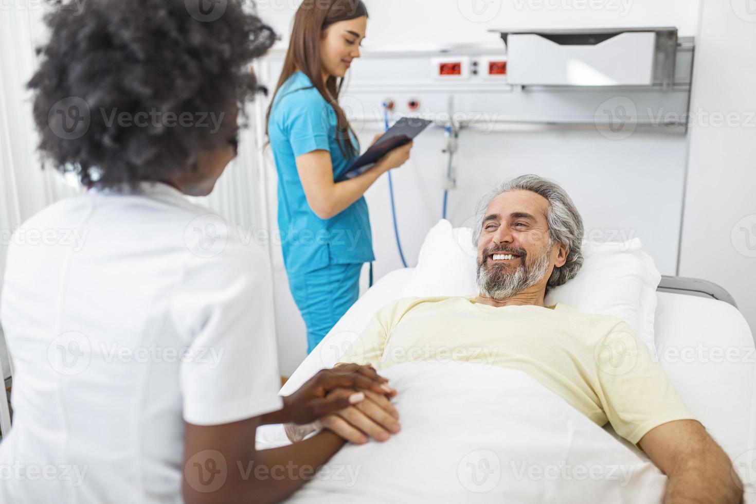 médecin professionnel consultant et réconfortant un patient âgé dans un lit d'hôpital ou conseillant la santé du diagnostic. médecin ou infirmière tenant les mains du patient âgé et le réconfortant photo