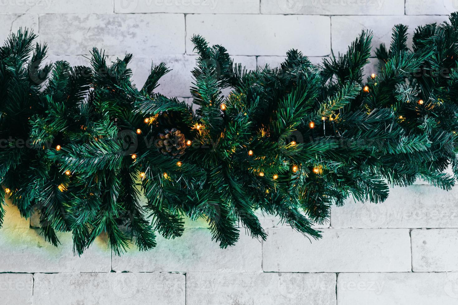 sapin de noël avec des lumières sur fond de briques blanches avec espace de copie photo