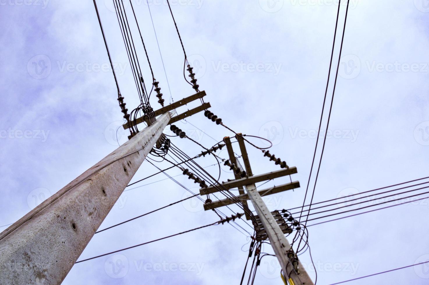 poteaux électriques en béton avec fils noirs sur fond de nuages blancs. photo