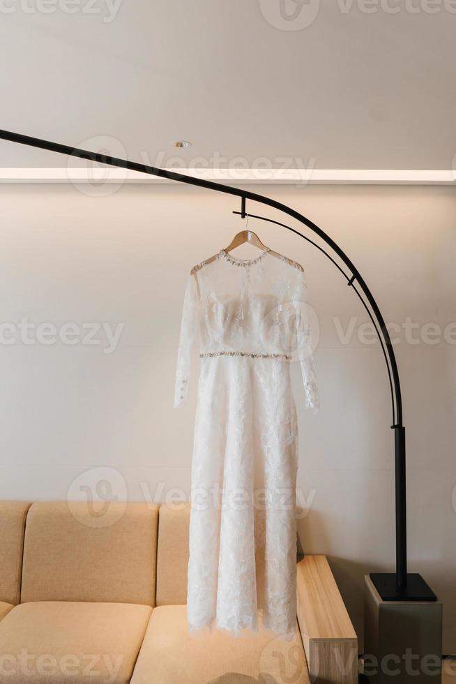 robe blanche ou robe de mariée suspendue en guise de préparation au mariage. photo