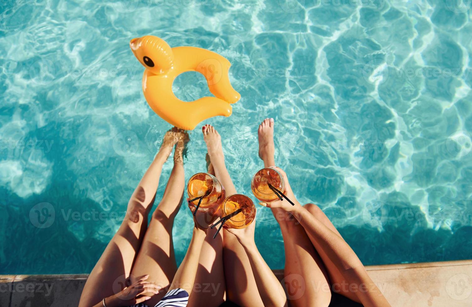 vue de dessus d'un groupe de jeunes gens heureux qui s'amusent dans la piscine pendant la journée photo