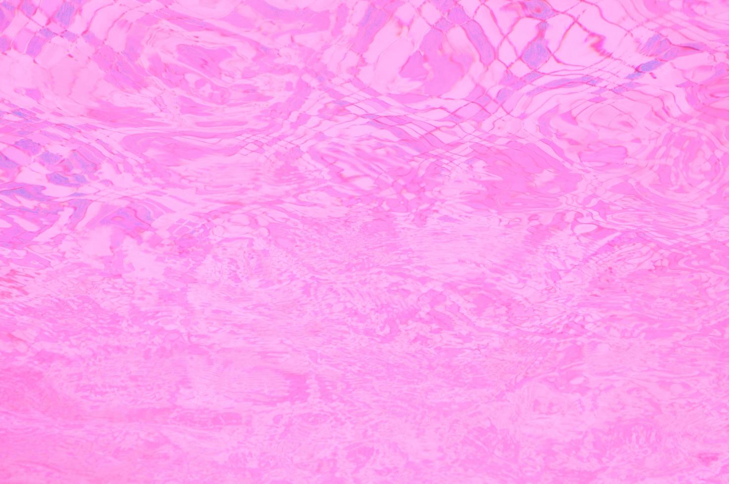 abstrait de l'eau rose défocalisé. reflet du soleil sur la surface de l'eau photo