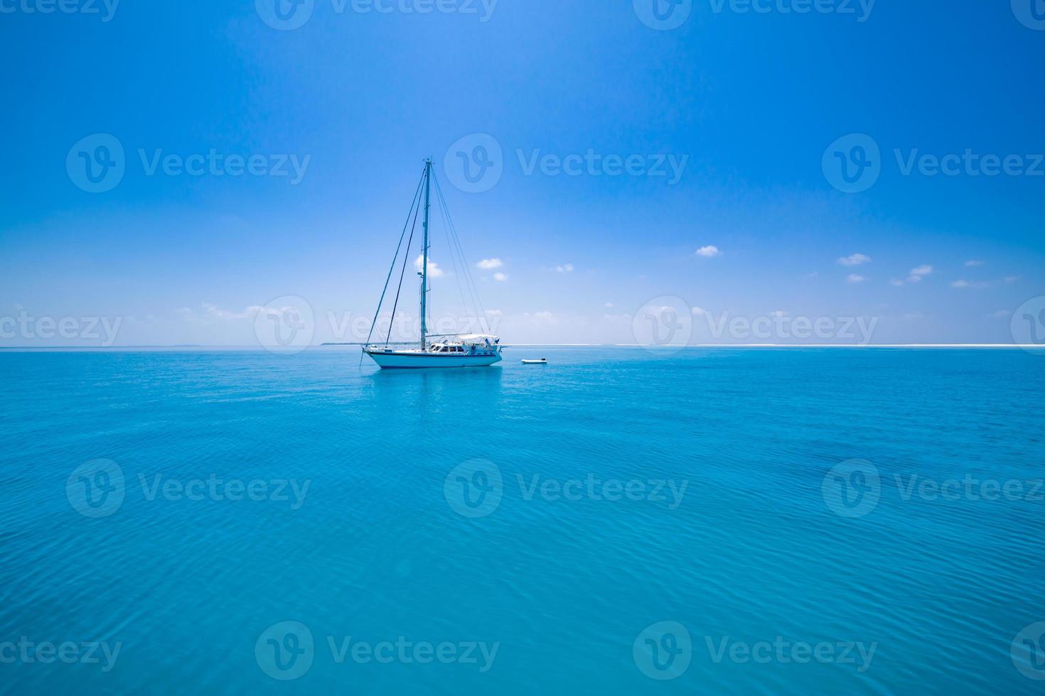 voilier blanc voyageant dans la mer bleue des maldives par une belle journée d'été ensoleillée au milieu de nulle part. mer tropicale et voilier. pas de voiles en mer calme photo