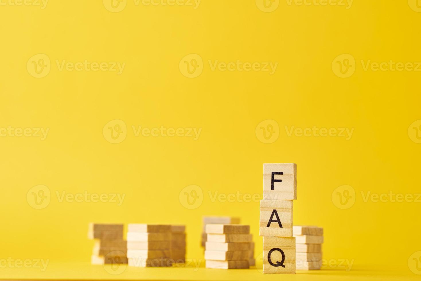 blocs de bois avec mot faq sur le baclground jaune. photo