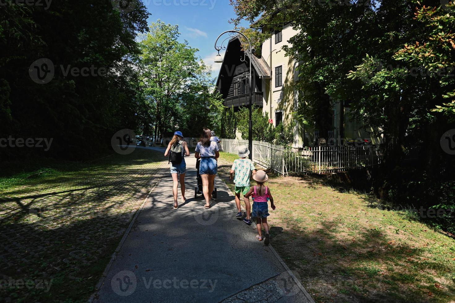 famille marchant sur le chemin du parc à bled, slovénie. photo