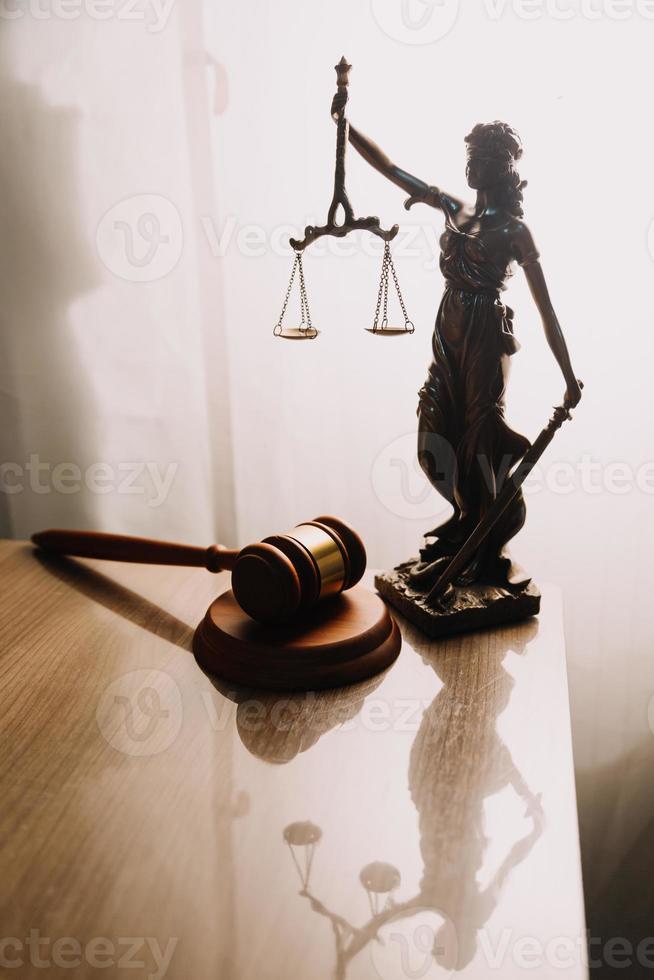 concept de justice et de droit. juge masculin dans une salle d'audience avec le marteau, travaillant avec, clavier d'ordinateur et d'accueil, lunettes, sur table à la lumière du matin photo