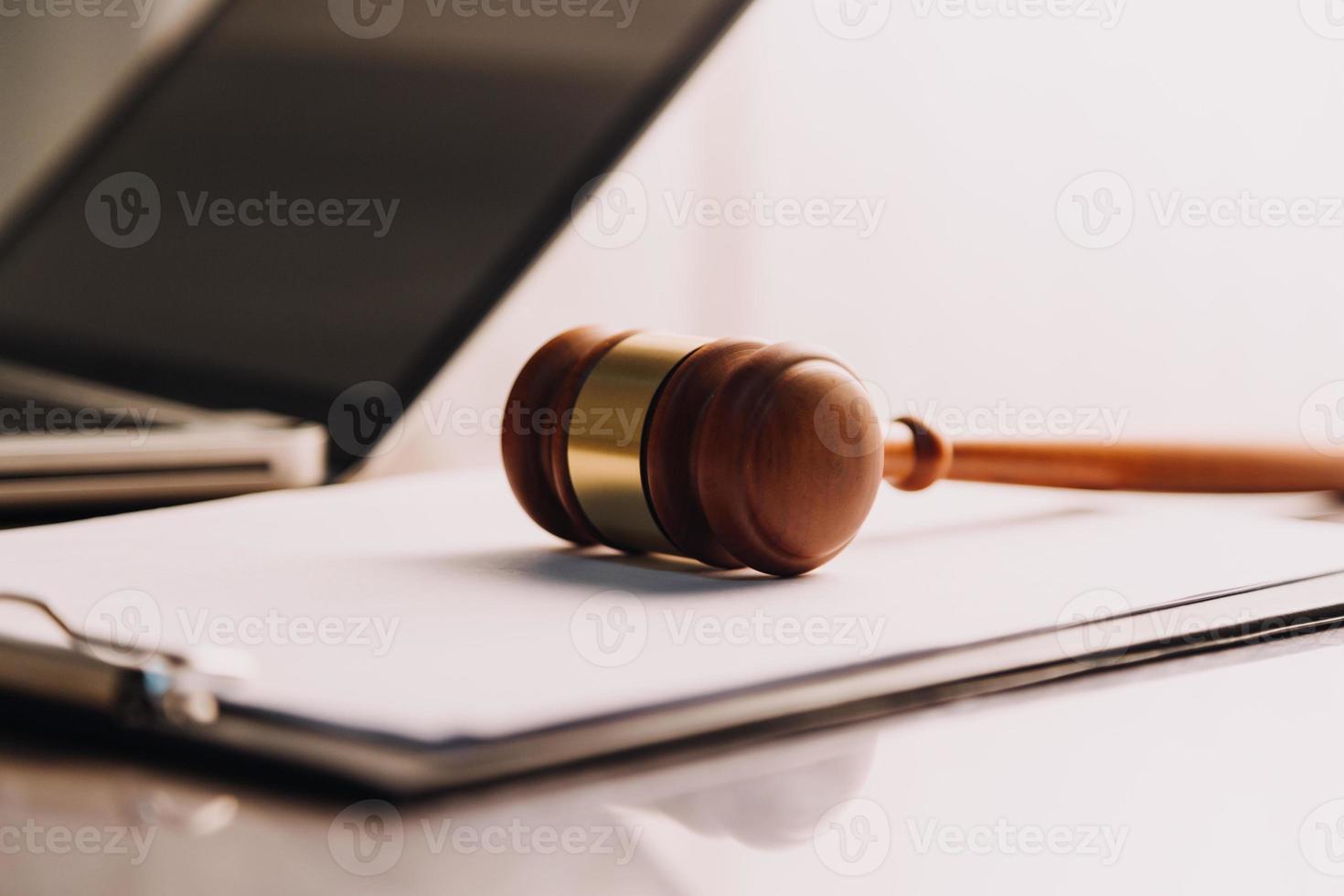 concept de justice et de droit. juge masculin dans une salle d'audience avec le marteau, travaillant avec, clavier d'ordinateur et d'accueil, lunettes, sur table à la lumière du matin photo