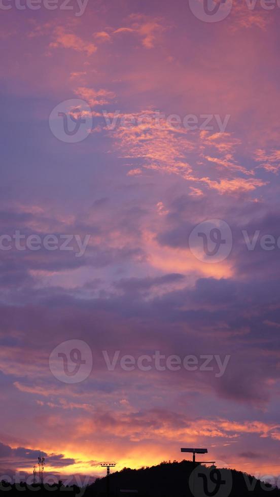 la belle vue sur le coucher de soleil avec les nuages colorés et la silhouette des montagnes en arrière-plan photo