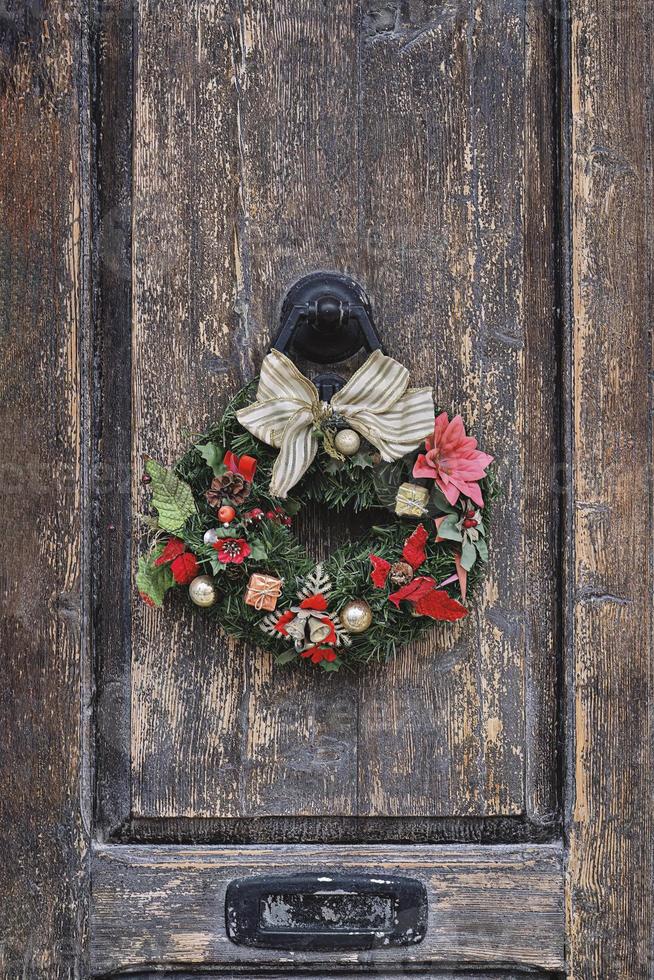 couronne de noël sur une vieille porte en bois. décoration de maison traditionnelle à noël photo