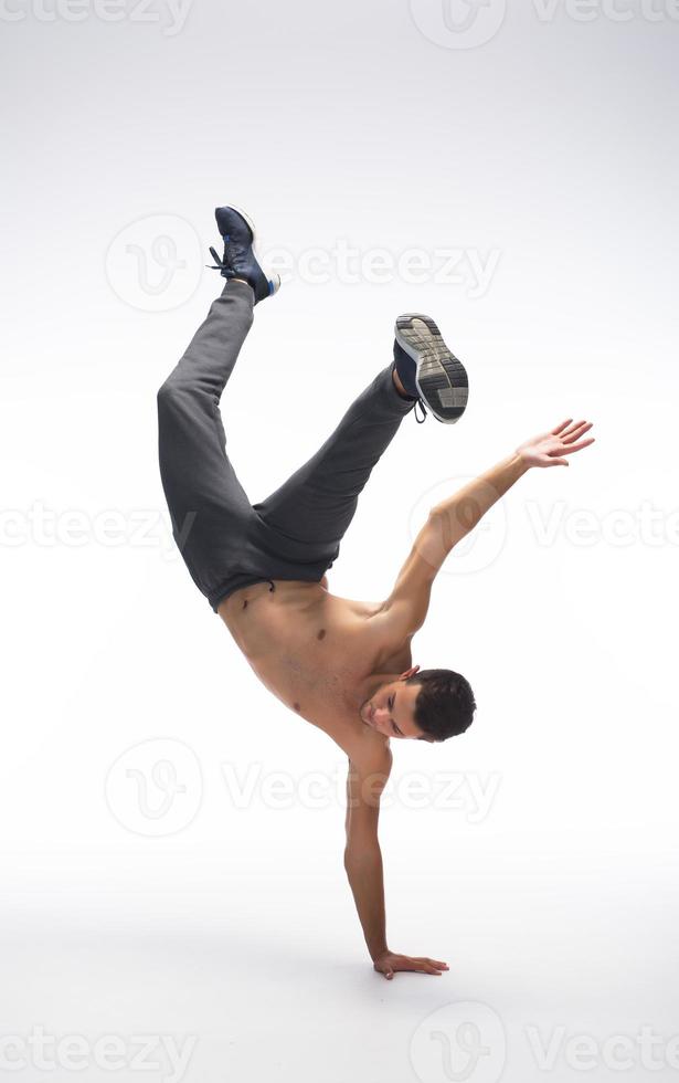 cool jeune break dancer effectuant en studio sur fond blanc. photo