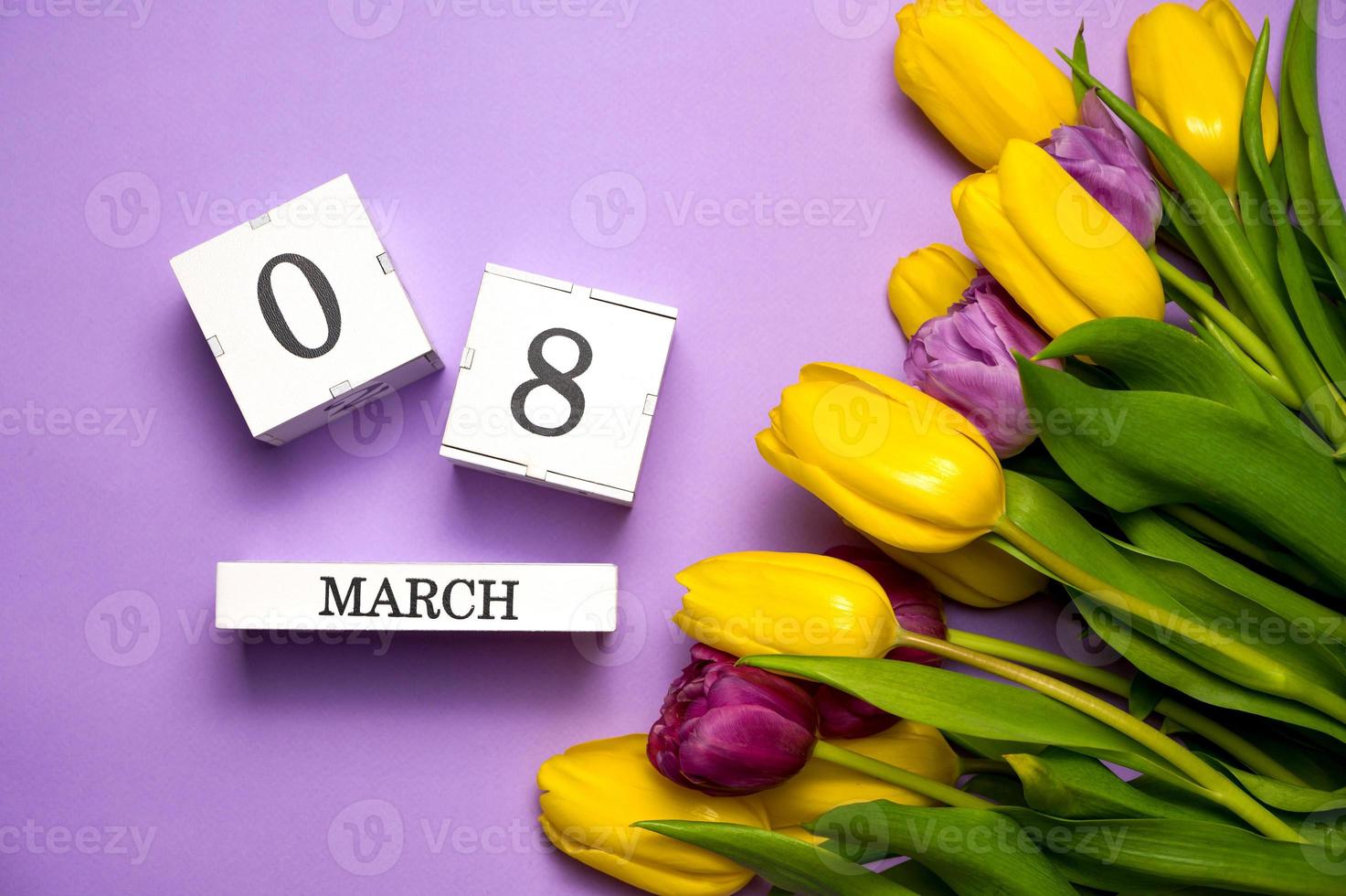 Notion du 8 mars. tulipes colorées sur violet pastel. journée internationale de la femme photo