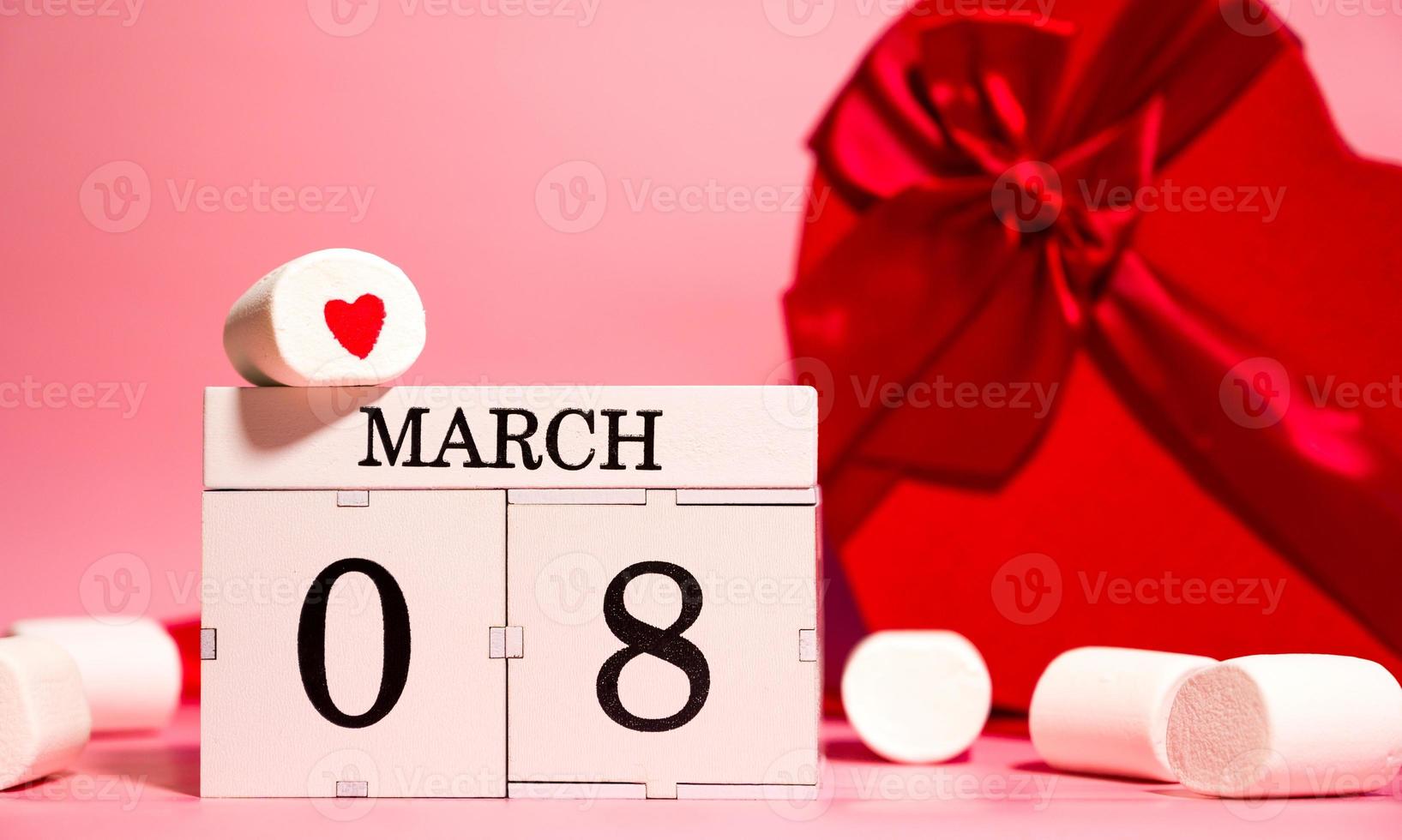 bannière créative de la journée de la femme avec des cadeaux en forme de coeur, des guimauves et un calendrier avec la date du 8 mars photo