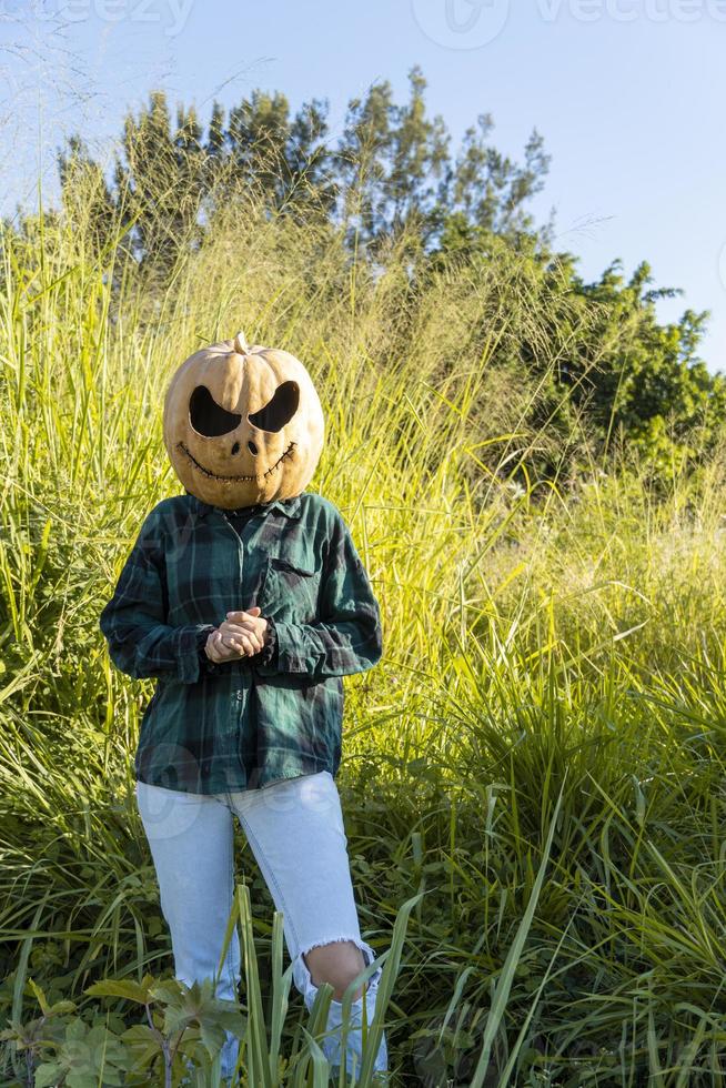 jeune femme avec une citrouille sur la tête pour halloween, jour des morts, mexique photo