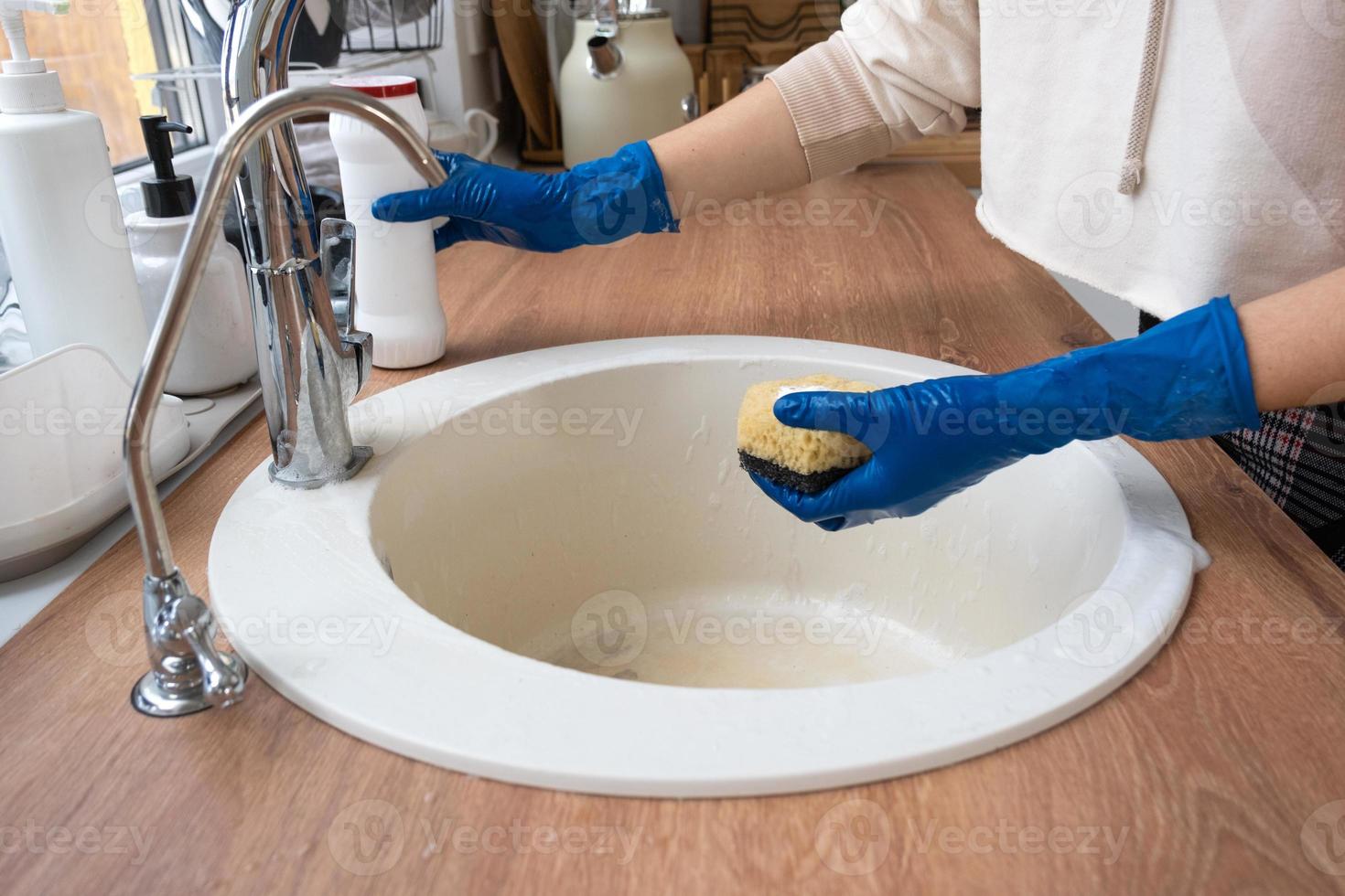 évier de nettoyage dans la cuisine, main dans les gants et éponge, détergent, poudre sèche. intérieur confortable de la maison, restauration de l'ordre, propreté, désinfection photo