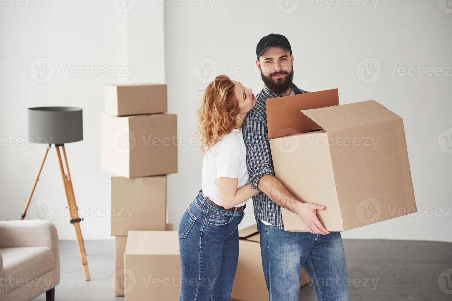 avec boîte ouverte dans les mains. couple heureux ensemble dans leur nouvelle maison. conception du déménagement photo