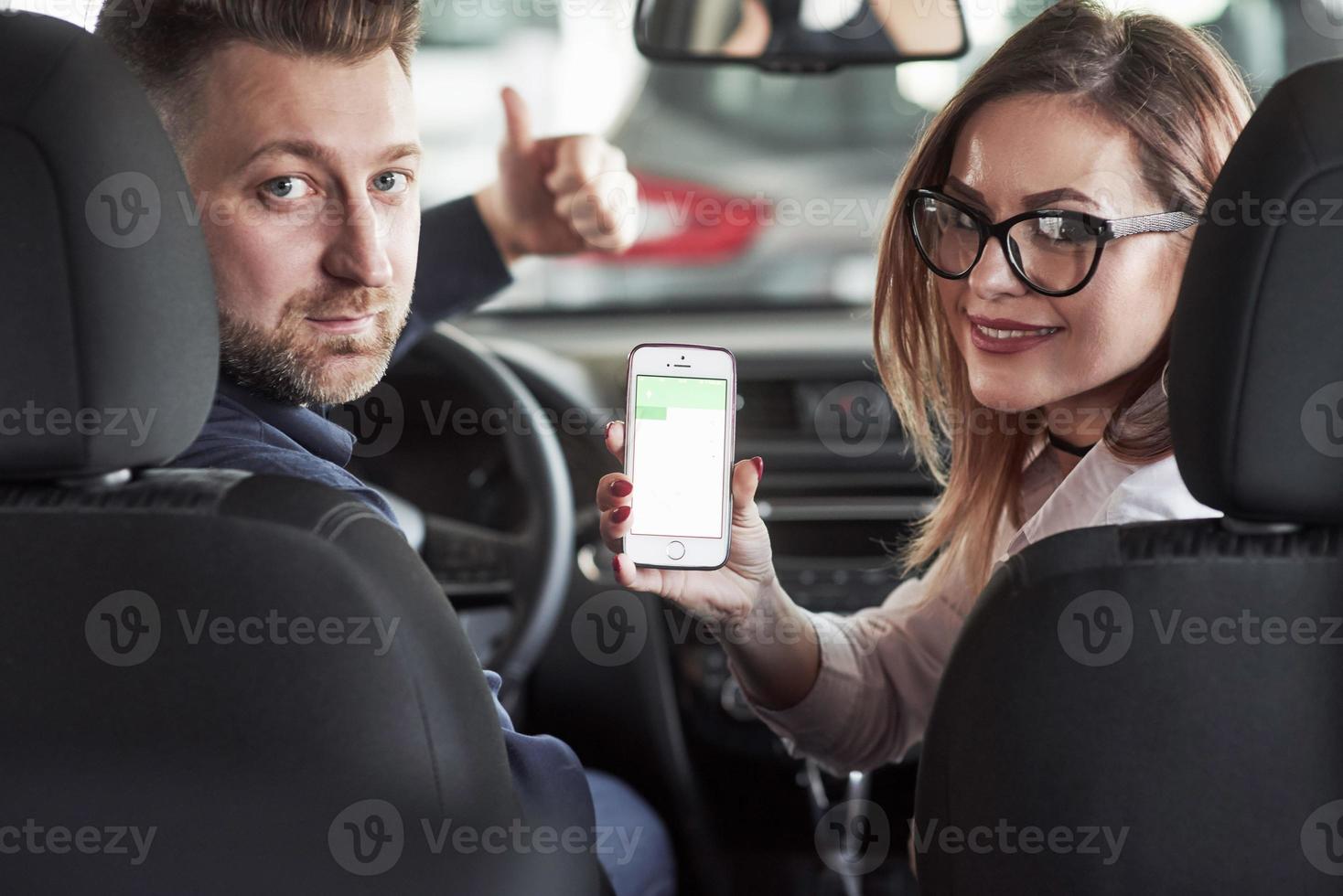 regardant derrière. directeur adjoint donnant des conseils et de l'aide au client dans un salon automobile photo