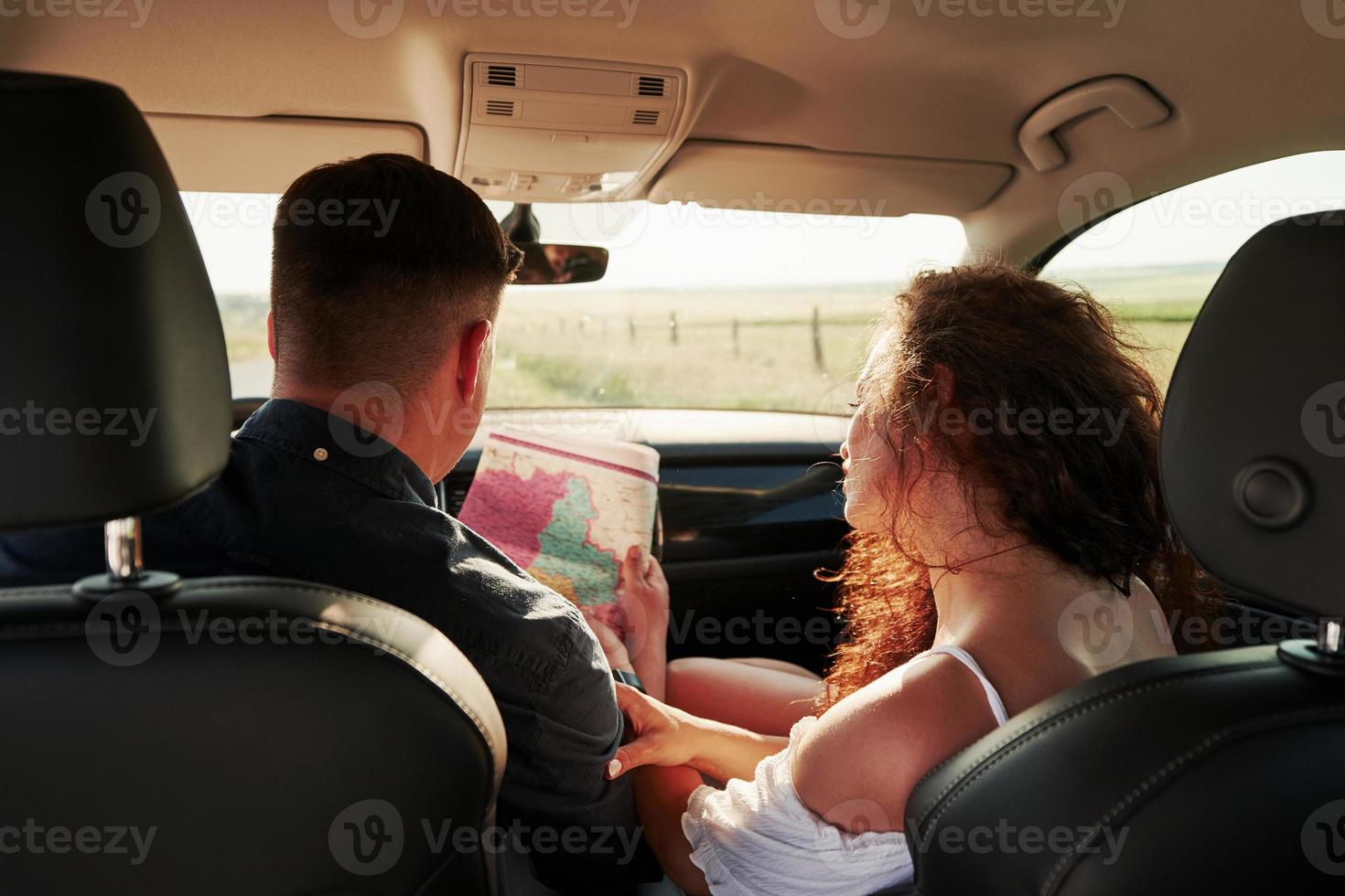 regardant la carte. de belles personnes sont dans la voiture moderne le week-end photo