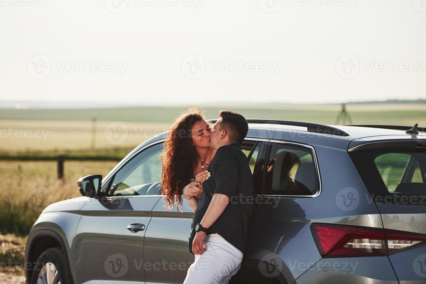 couple heureux s'embrassant par la fenêtre de la voiture. scène champêtre. au jour ensoleillé photo