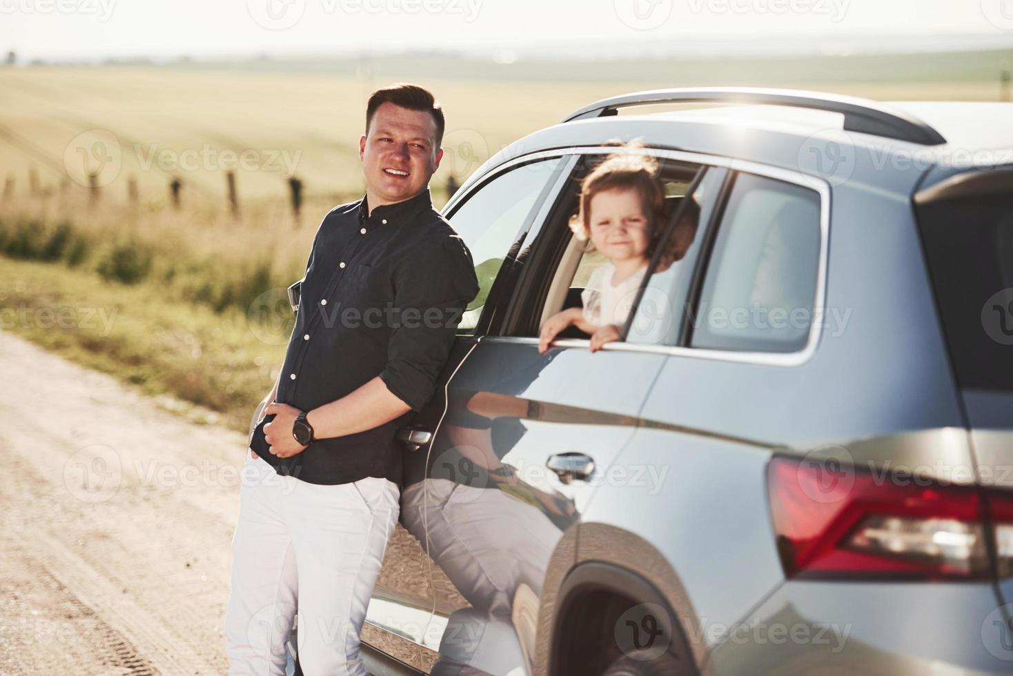 heureux ensemble. de belles personnes sont dans la voiture moderne le week-end photo