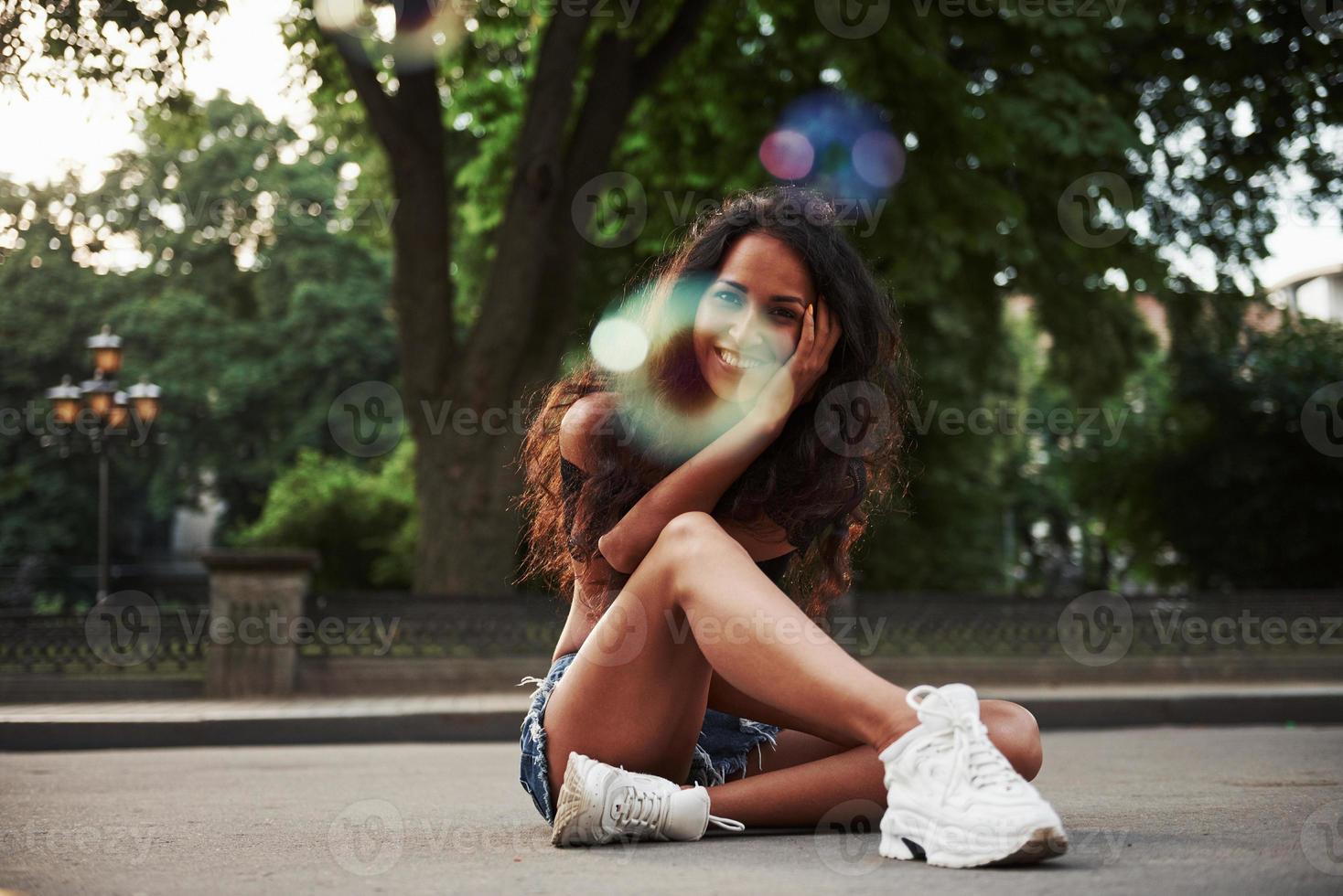 jolie fille. belle femme aux cheveux noirs bouclés passer du bon temps dans la ville pendant la journée photo